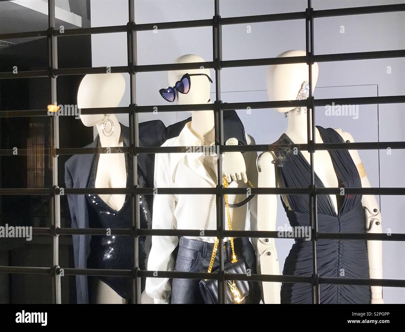 Three mannequins in the shop window of a closed shop. - Smartphone Captured Stock Image