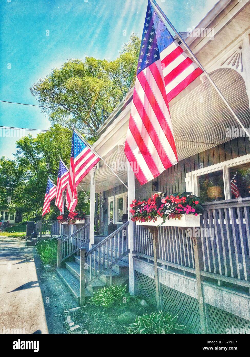 American flags flying outside of store front in Egg Harbor WI in summer - Smartphone Captured Stock Image
