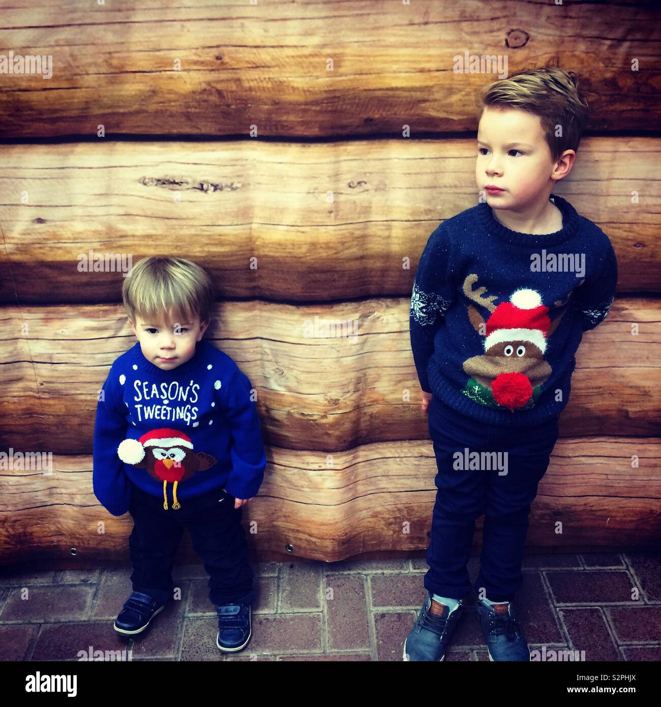 Boys, brothers in Christmas Jumpers waiting to see Father Christmas at