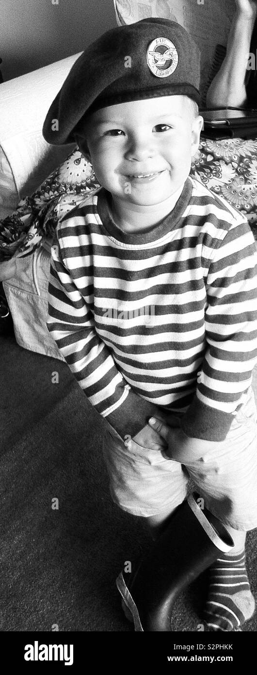 Cheeky toddler boy wearing RAF cadet beret future pilot in a