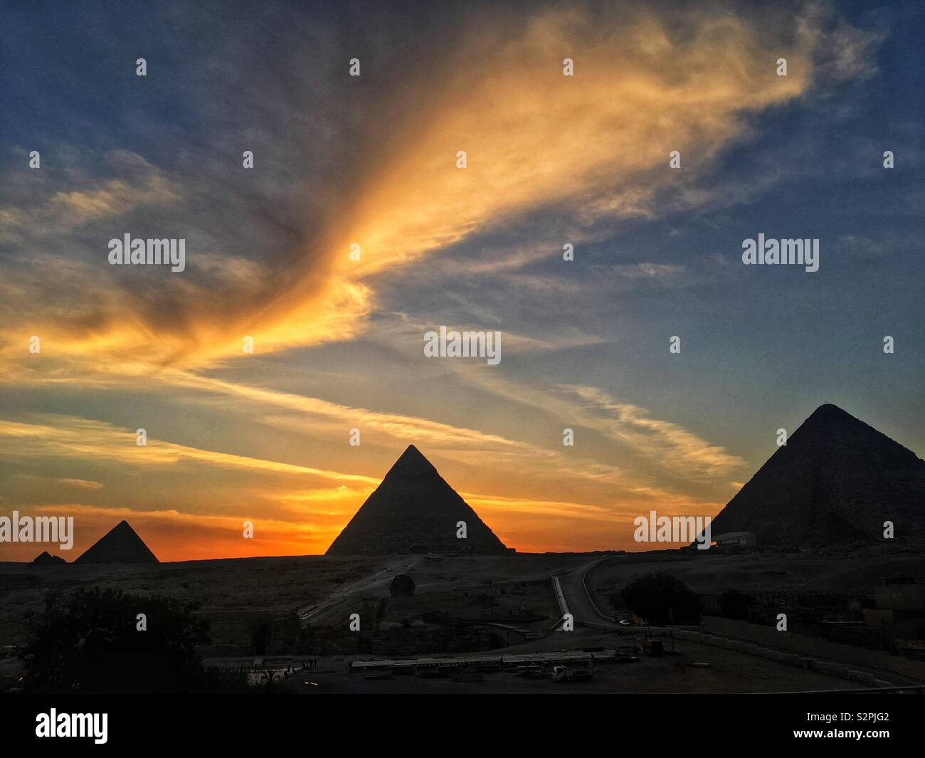 Sunset behind the pyramids of Giza Stock Photo - Alamy