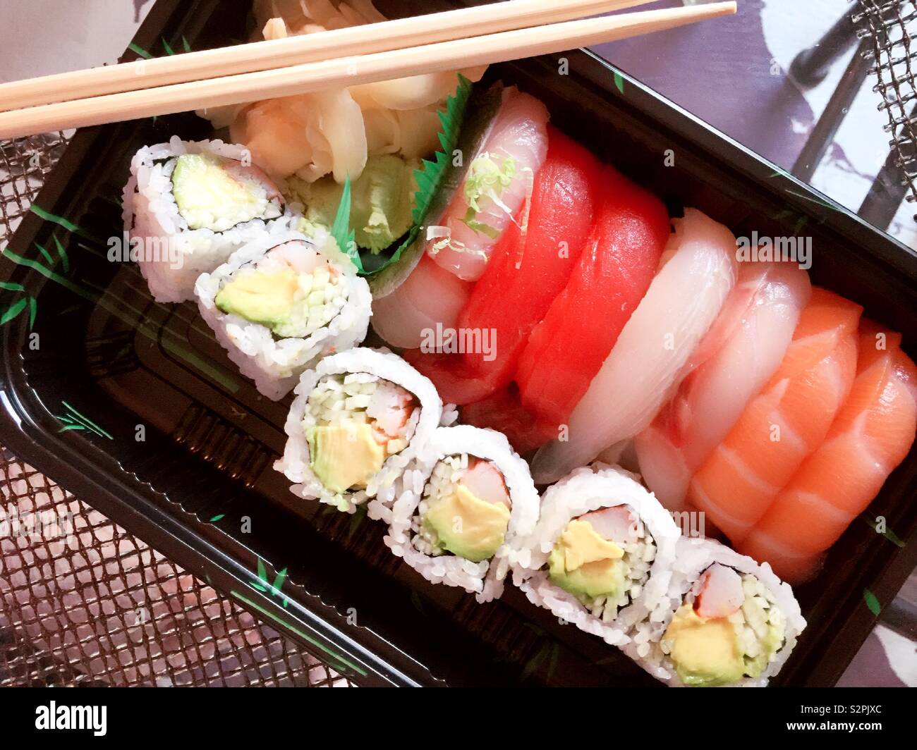 A Japanese delivery meal of sushi pieces and California roll, New York City, USA - Smartphone Captured Stock Image
