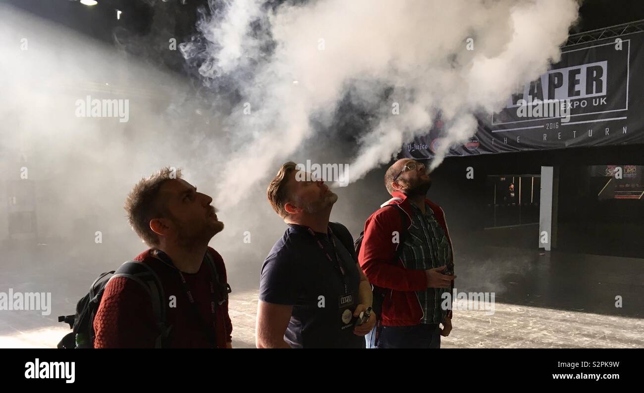 E cigarette users exhaling vapour at UK vape event Stock Photo