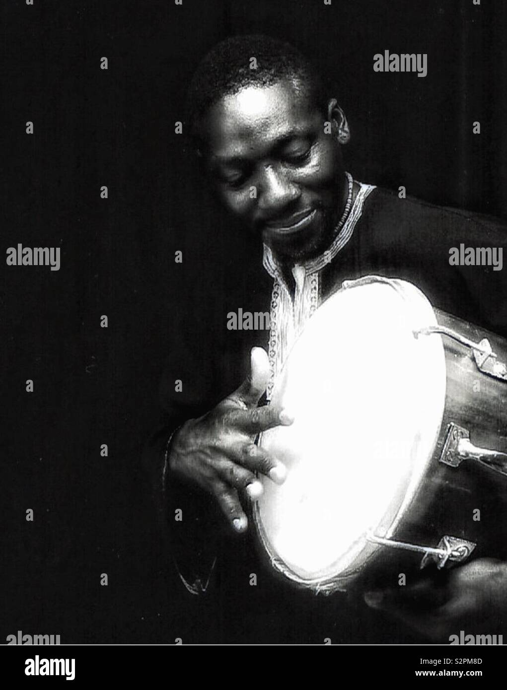 An African gentleman playing a drum. - Smartphone Captured Stock Image