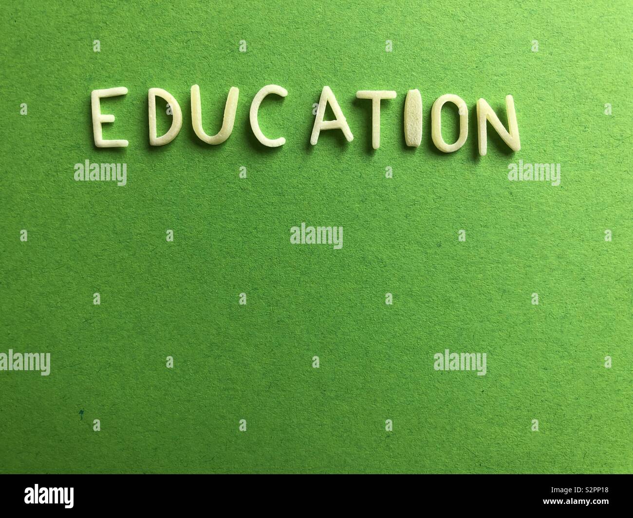 The word education on a green background with copy space Stock Photo