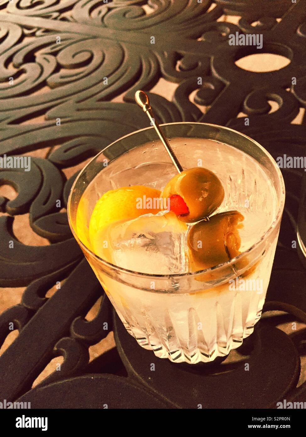 A martini cocktail on the rocks in a crystal glass on a wrought iron patio table, USA Stock