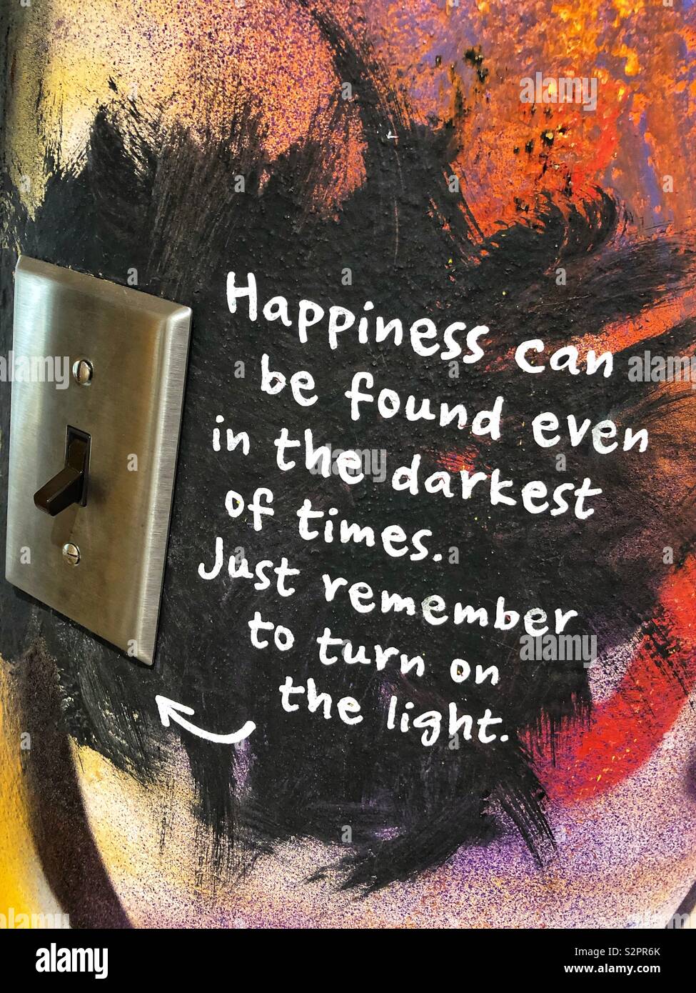 Inspirational quote painted next to a light switch. - Smartphone Captured Stock Image