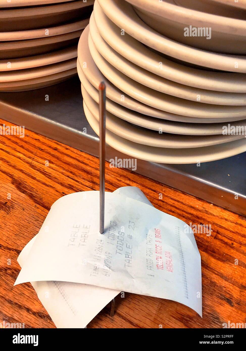 Restaurant counter close up of orders spindle and plates, USA - Smartphone Captured Stock Image