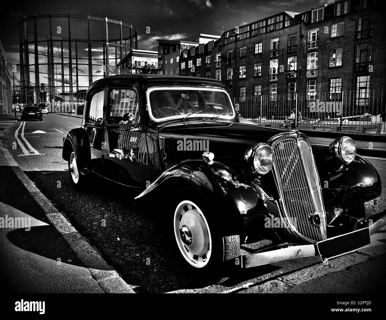Vintage car parked near a gas holder in east London Stock Photo Alamy