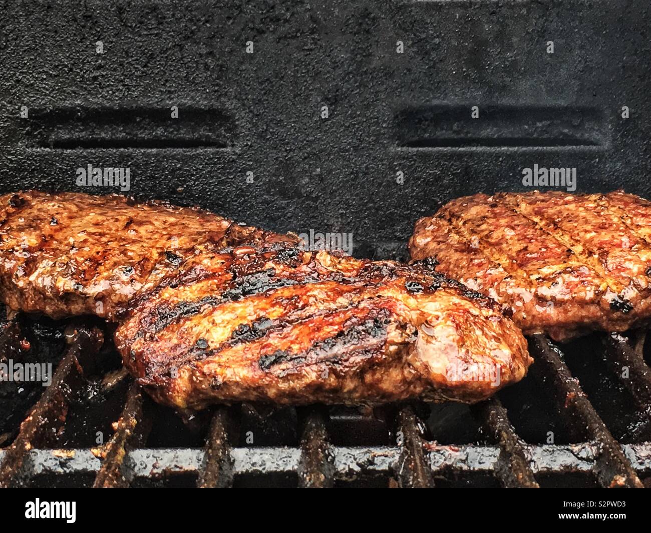 Fresh delicious hamburger patties grilling on the barbecue grill Stock