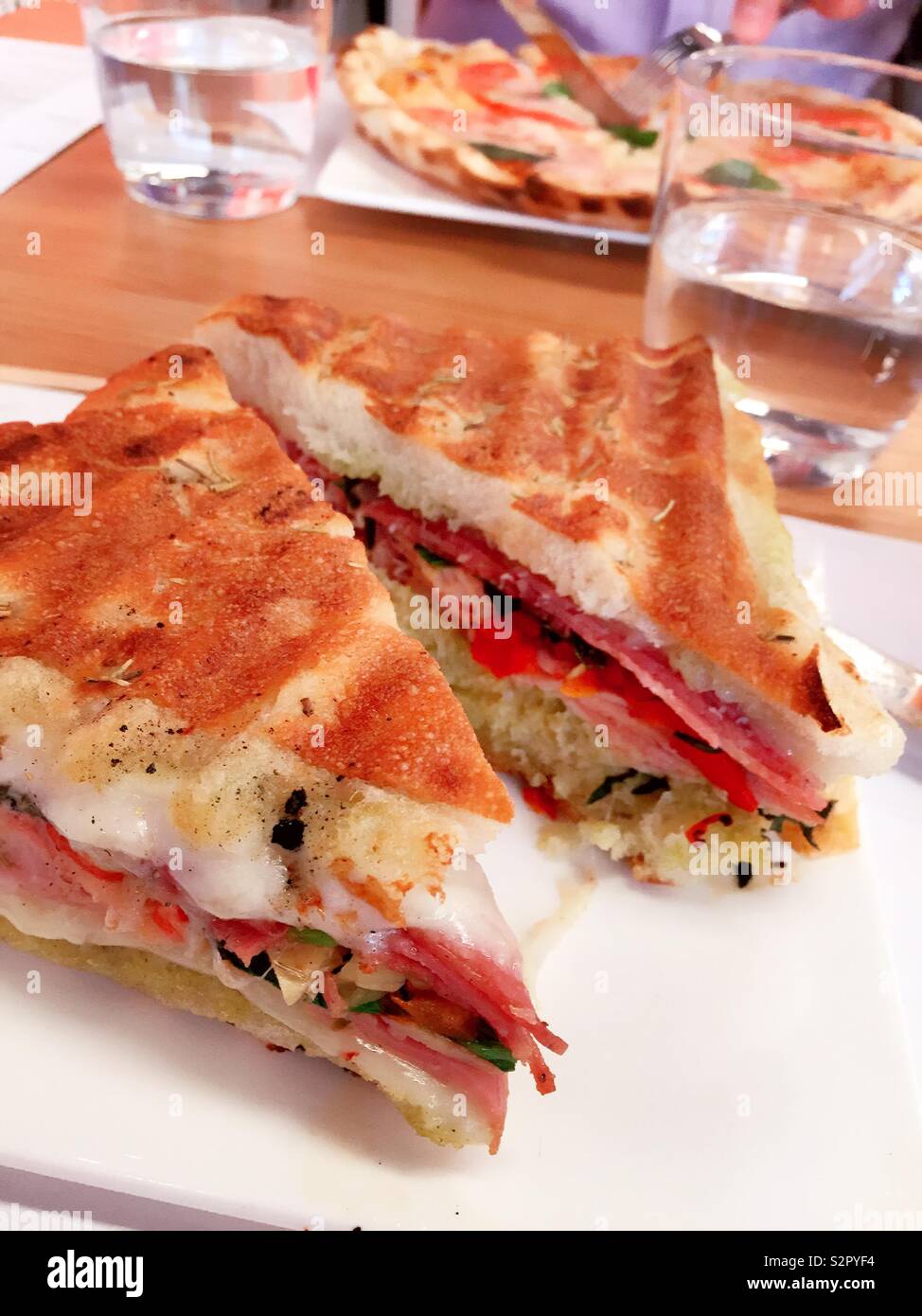 A Panini and a pizza are served to diners in an Italian restaurant - Smartphone Captured Stock Image