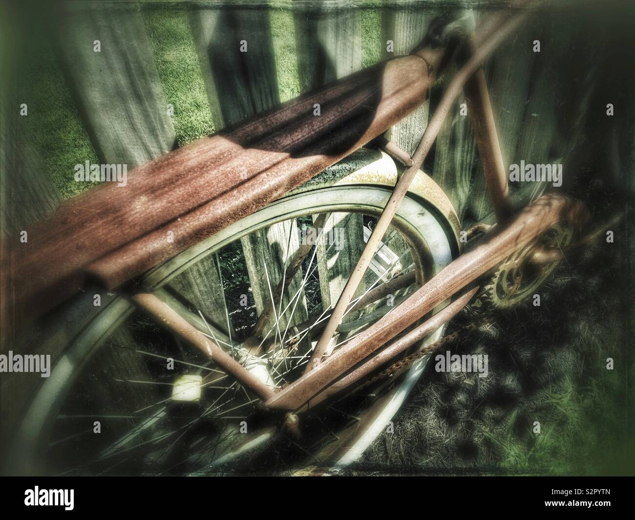 Rusty vintage bicycle parked against a wooden fence - Smartphone Captured Stock Image