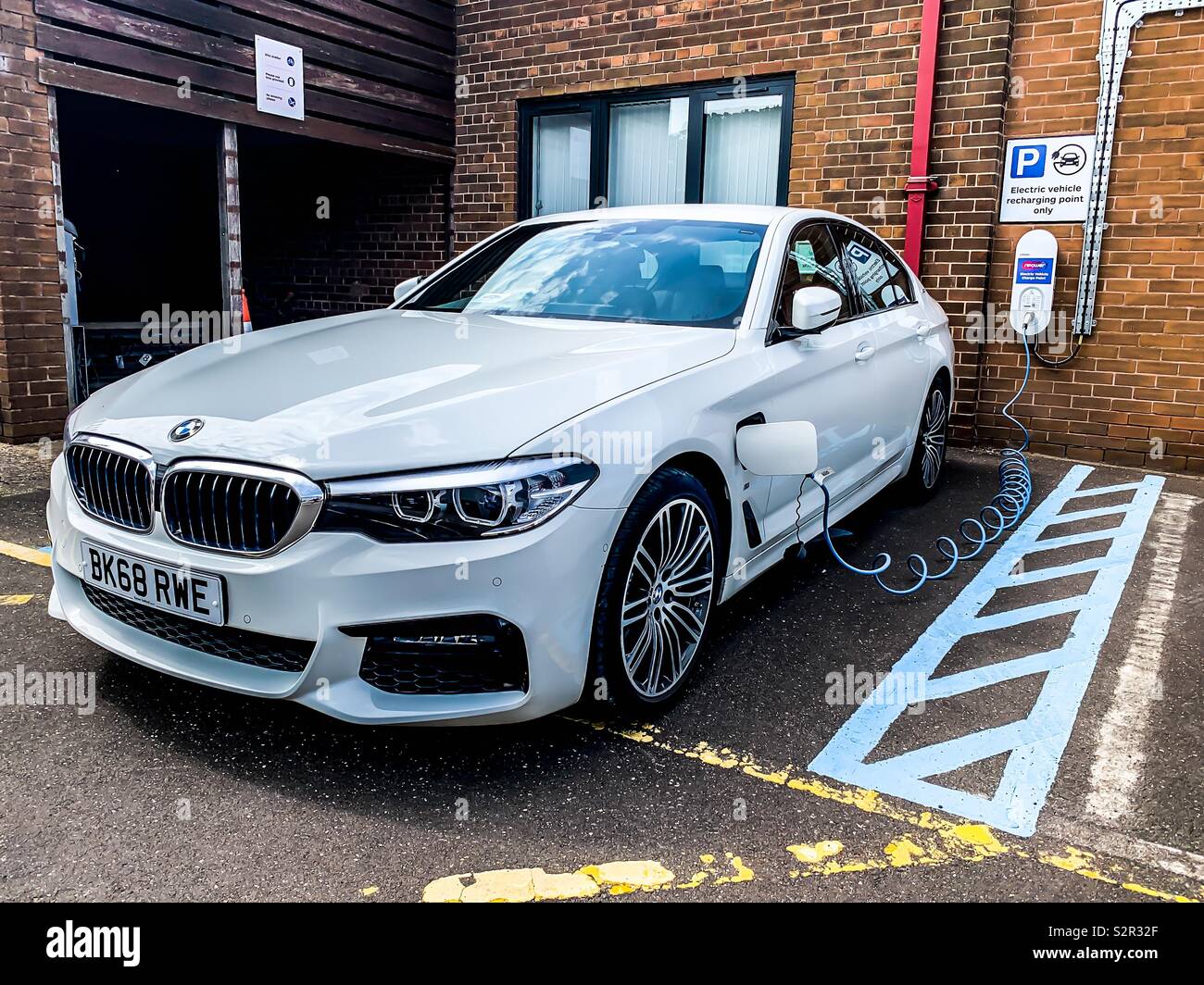 White BMW 530e electric vehicle charging Stock Photo