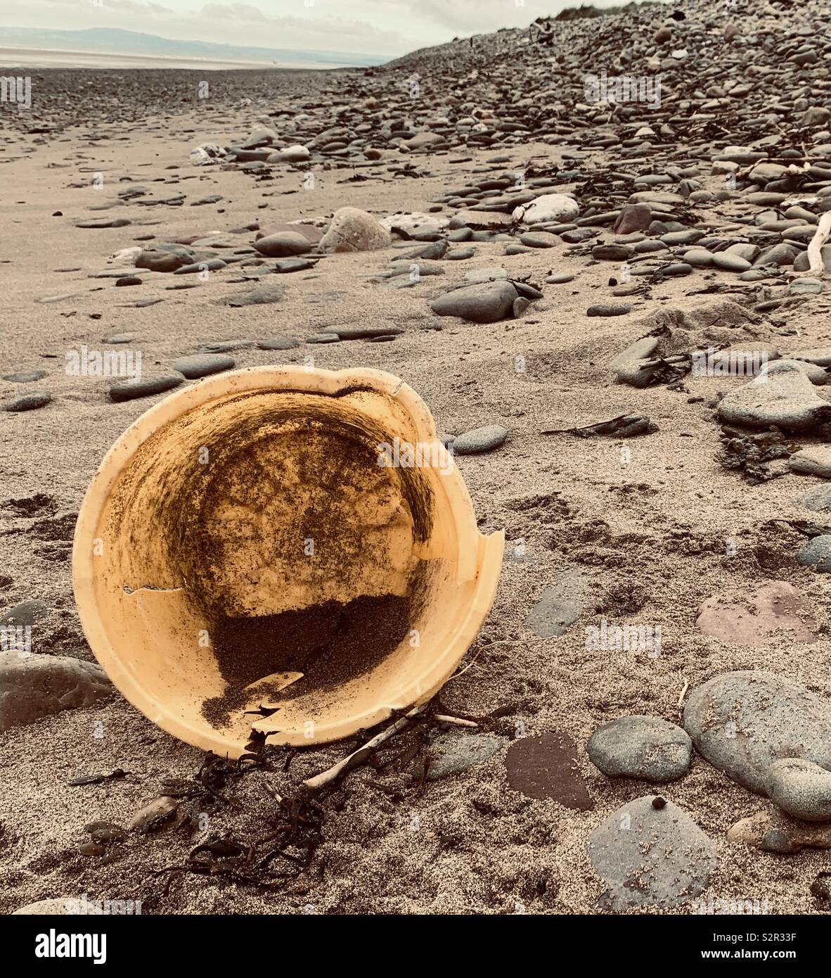 Yellow plastic bucket on beach Stock Photo