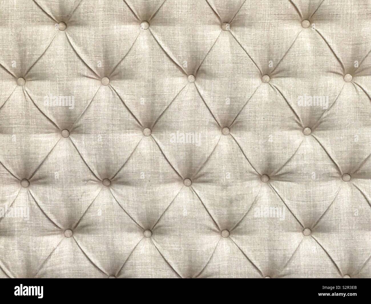 Finely tailored upholstery of white grey furniture with diagonal decoration and buttons. Stock Photo