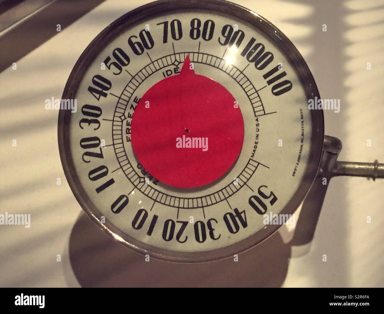 Vintage round analog thermometer reads 75°, USA - Smartphone Captured Stock Image