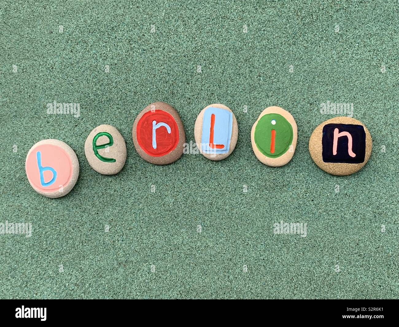 Berlin, capital city of Germany celebrated with a colored composition of stones over green sand Stock Photo