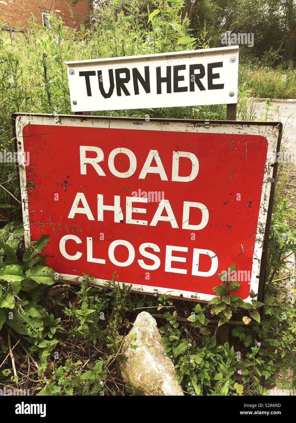 Road ahead closed sign with turn here advice Stock Photo Alamy