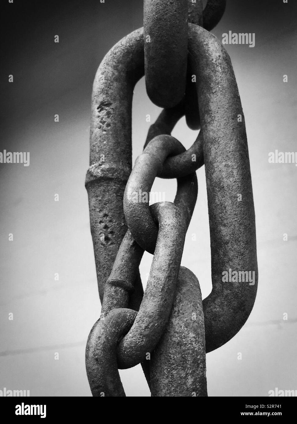 Small chain within a big chain link.  Unity, bond, union, linked, exit, ties, Brexit.  Chained together.  Missing link. Covid coronavirus metaphor - Smartphone Captured Stock Image