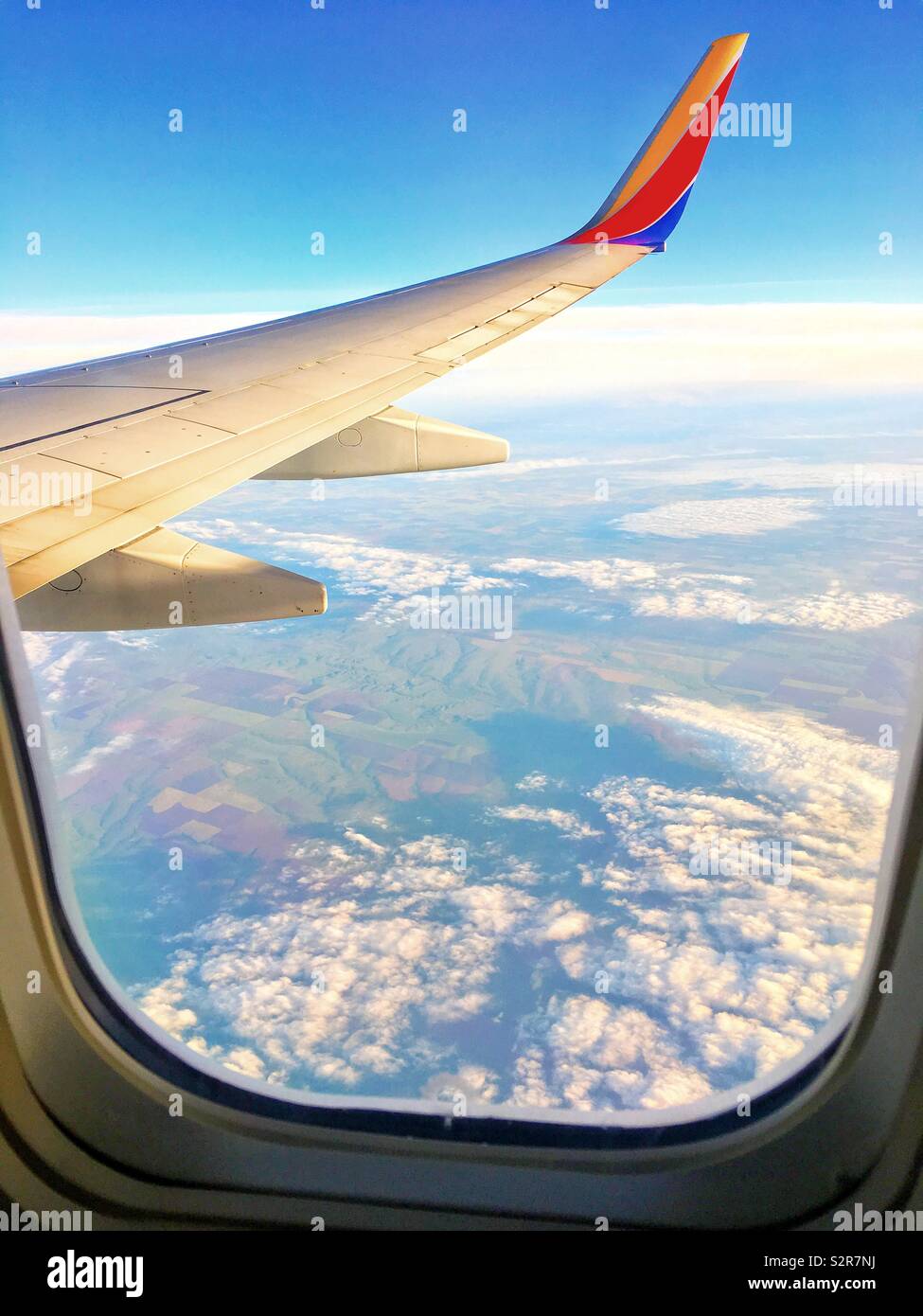 Southwest Airlines plane flying over clouds and the Southwest - Smartphone Captured Stock Image