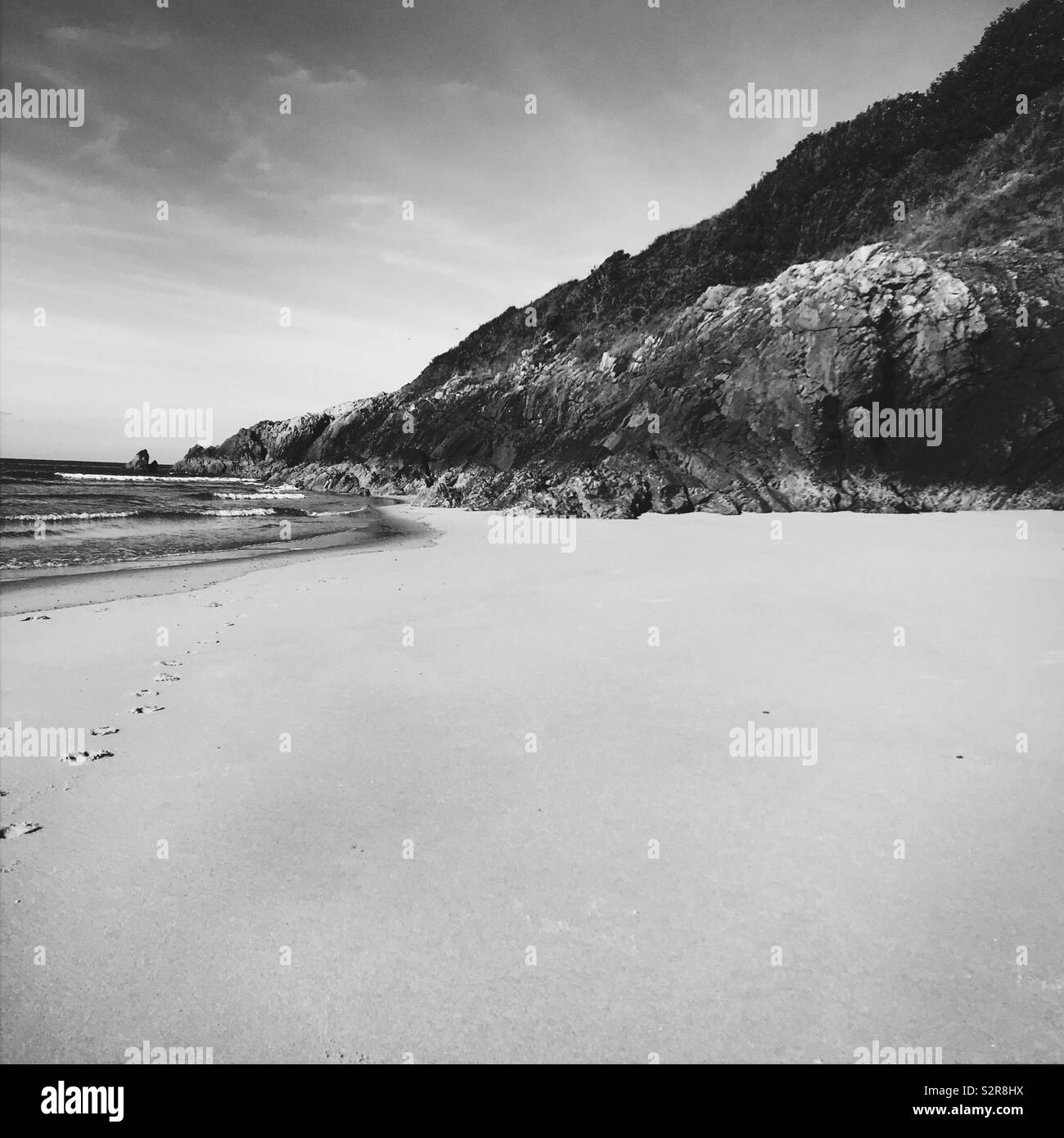 Empty cove on beach with footsteps, black and white Stock Photo