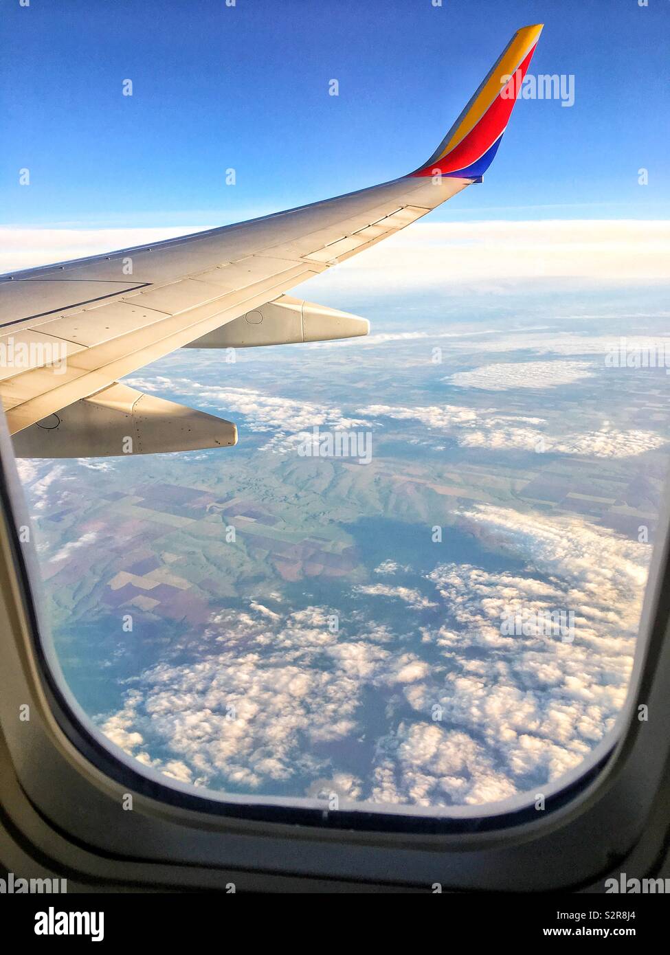 Southwest Airlines plane flying over clouds and the Southwest Stock Photo Alamy