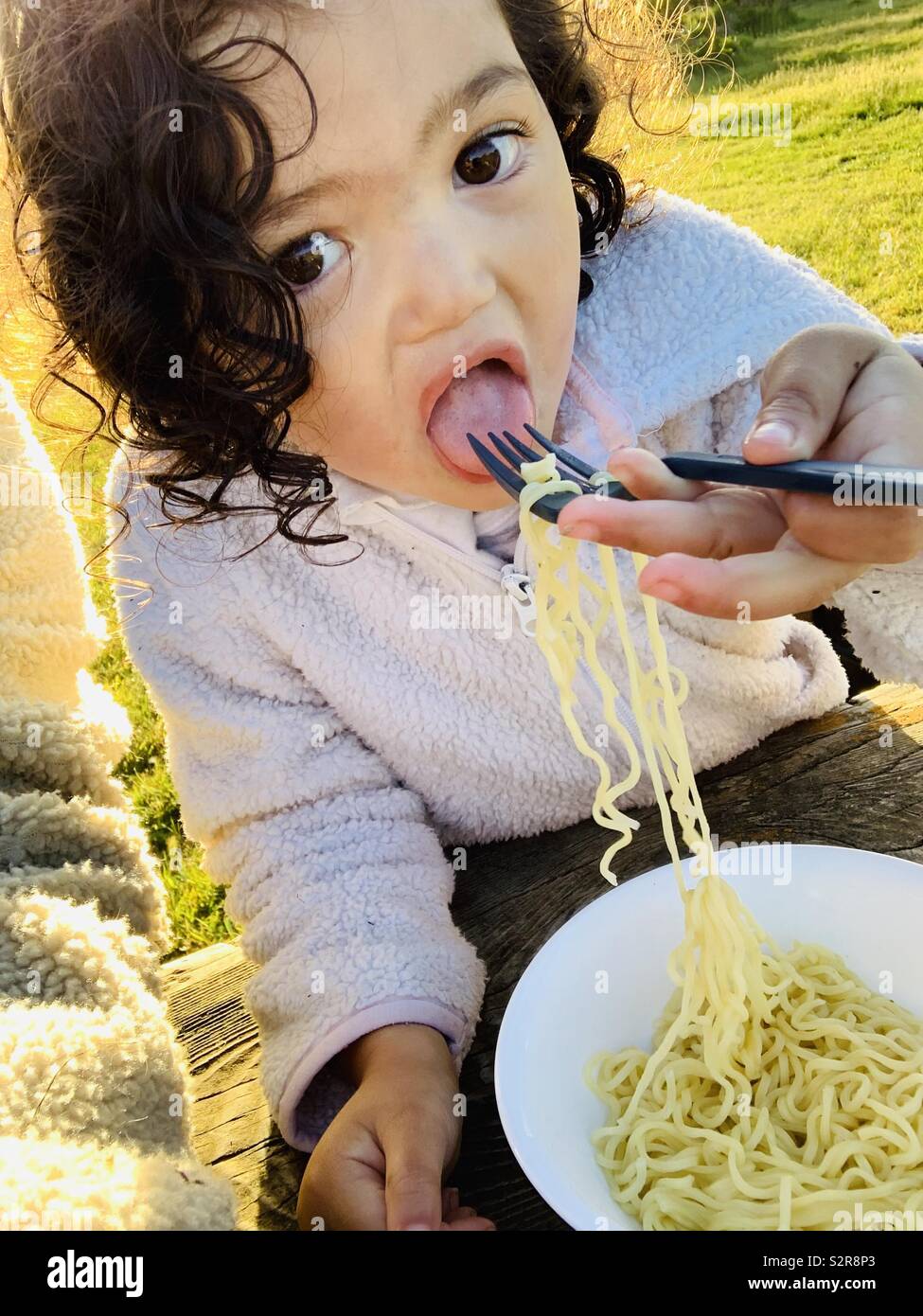 Young girl eating noodles Stock Photo Alamy
