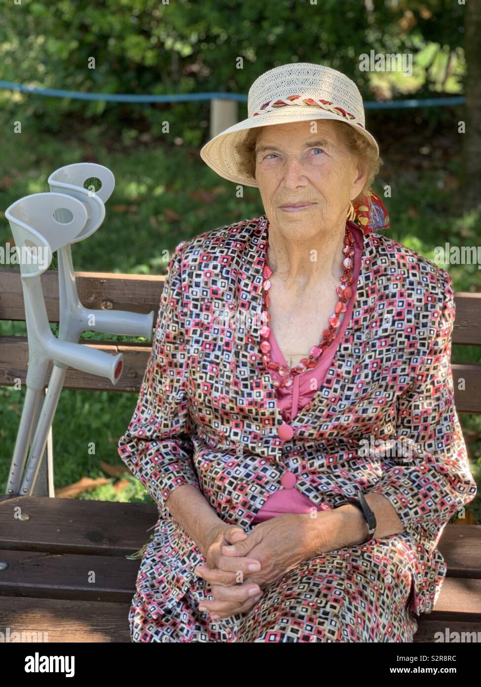 Nonagenarian woman sitting on a public bench - Smartphone Captured Stock Image