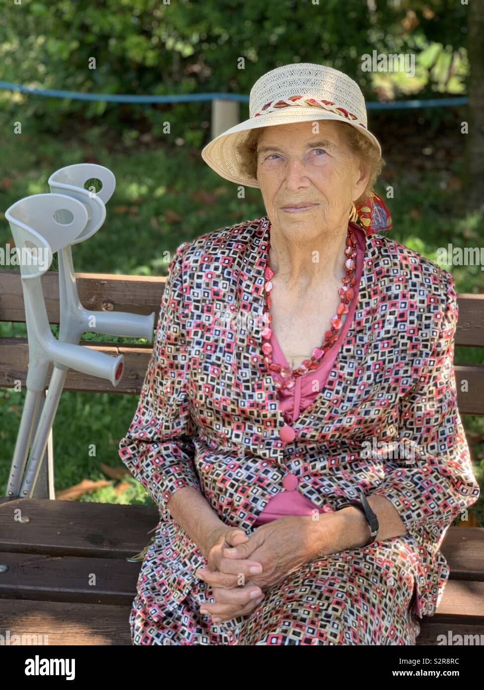 Nonagenarian woman sitting on a public bench Stock Photo