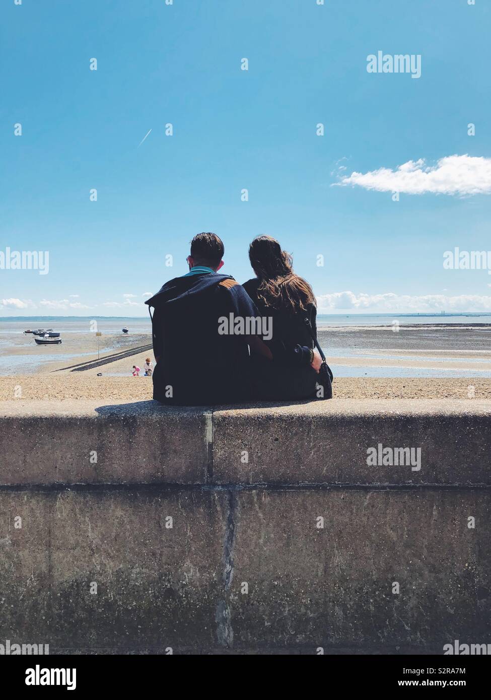 Couple sitting at beach. - Smartphone Captured Stock Image