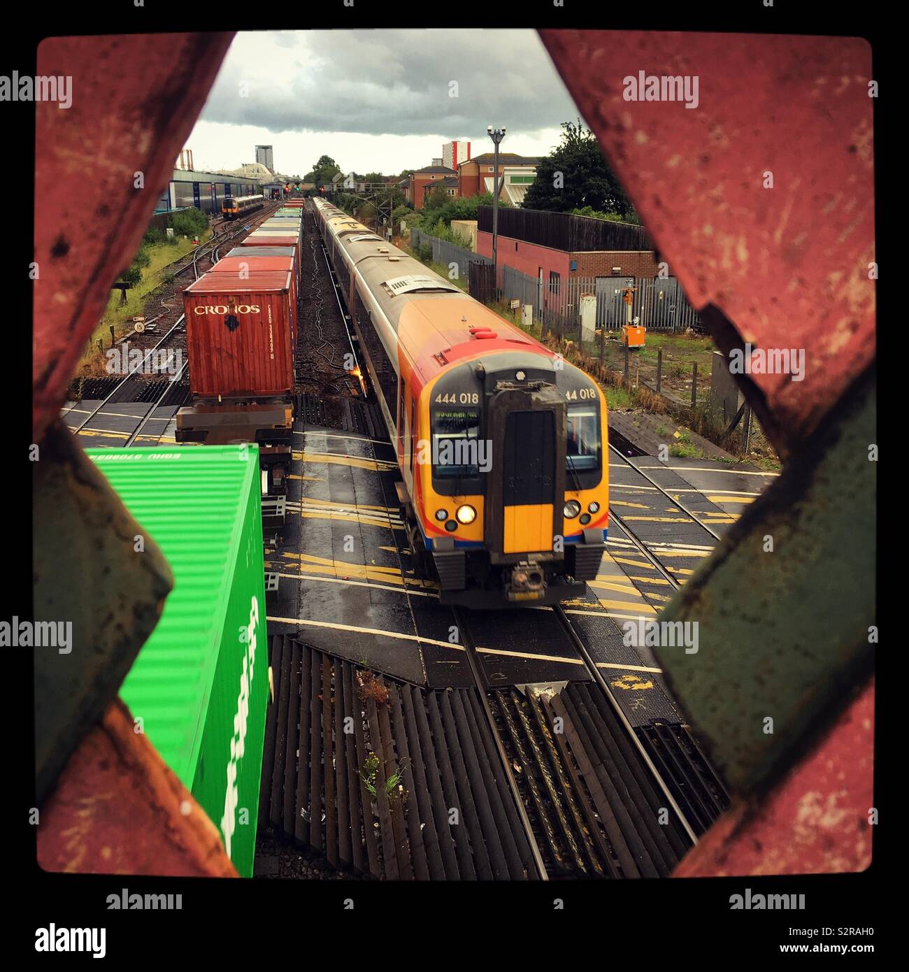 Two trains passing on a level crossing from a footbridge overhead. Southampton, Hampshire. Stock Photo