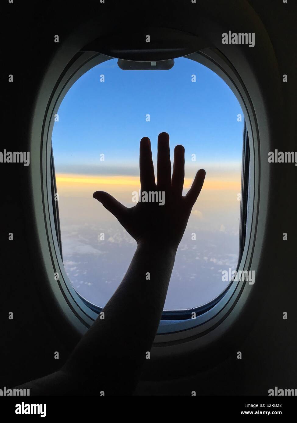 Child hand against an airplane window. - Smartphone Captured Stock Image
