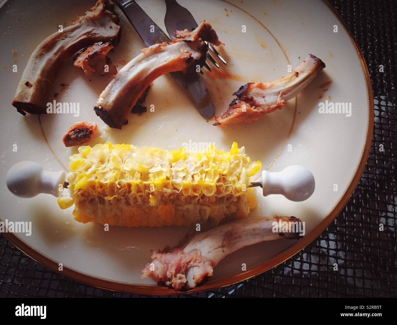 Completely eaten and finished meal of baby back ribs and corn on the cob, USA - Smartphone Captured Stock Image