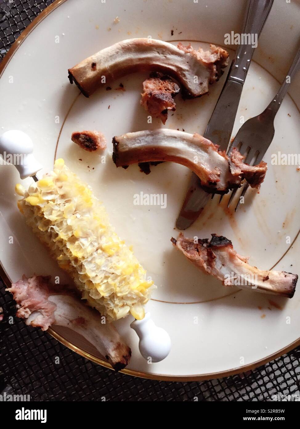 Completely eaten and finished meal of baby back ribs and corn on the cob, USA - Smartphone Captured Stock Image