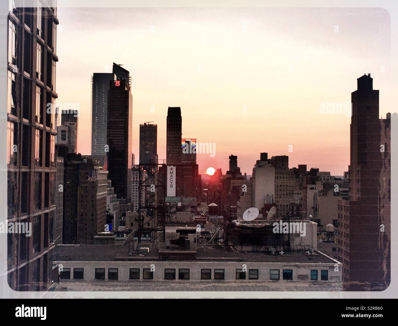 Silhouettes of skyscrapers in midtown Manhattan including Hudson yards with a vibrant red ball sunset, NYC, USA - Smartphone Captured Stock Image