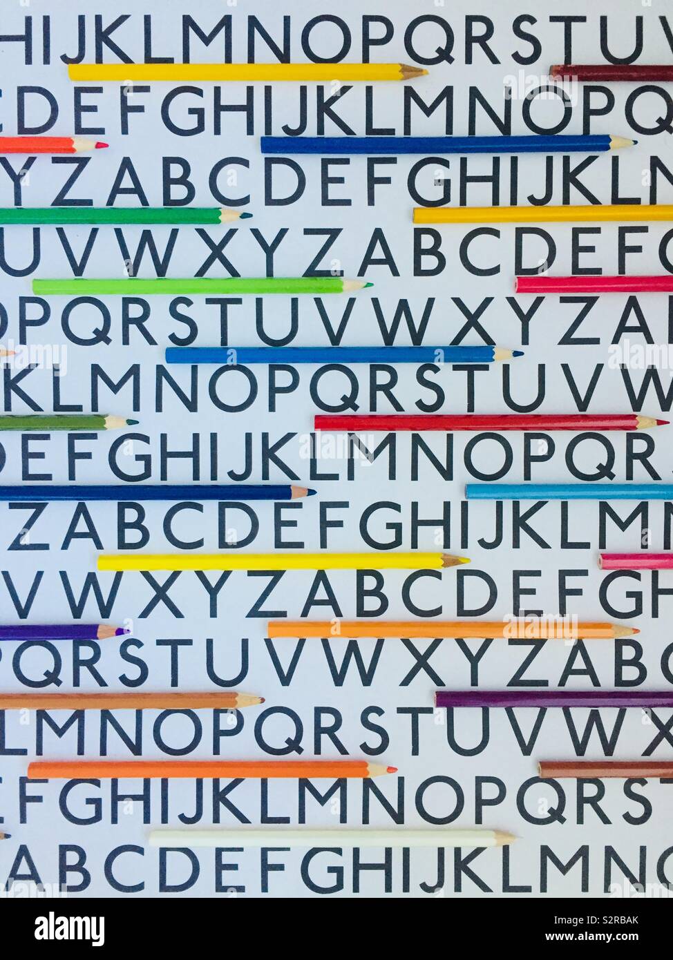 The alphabet with an assortment of brightly coloured pencils - Smartphone Captured Stock Image