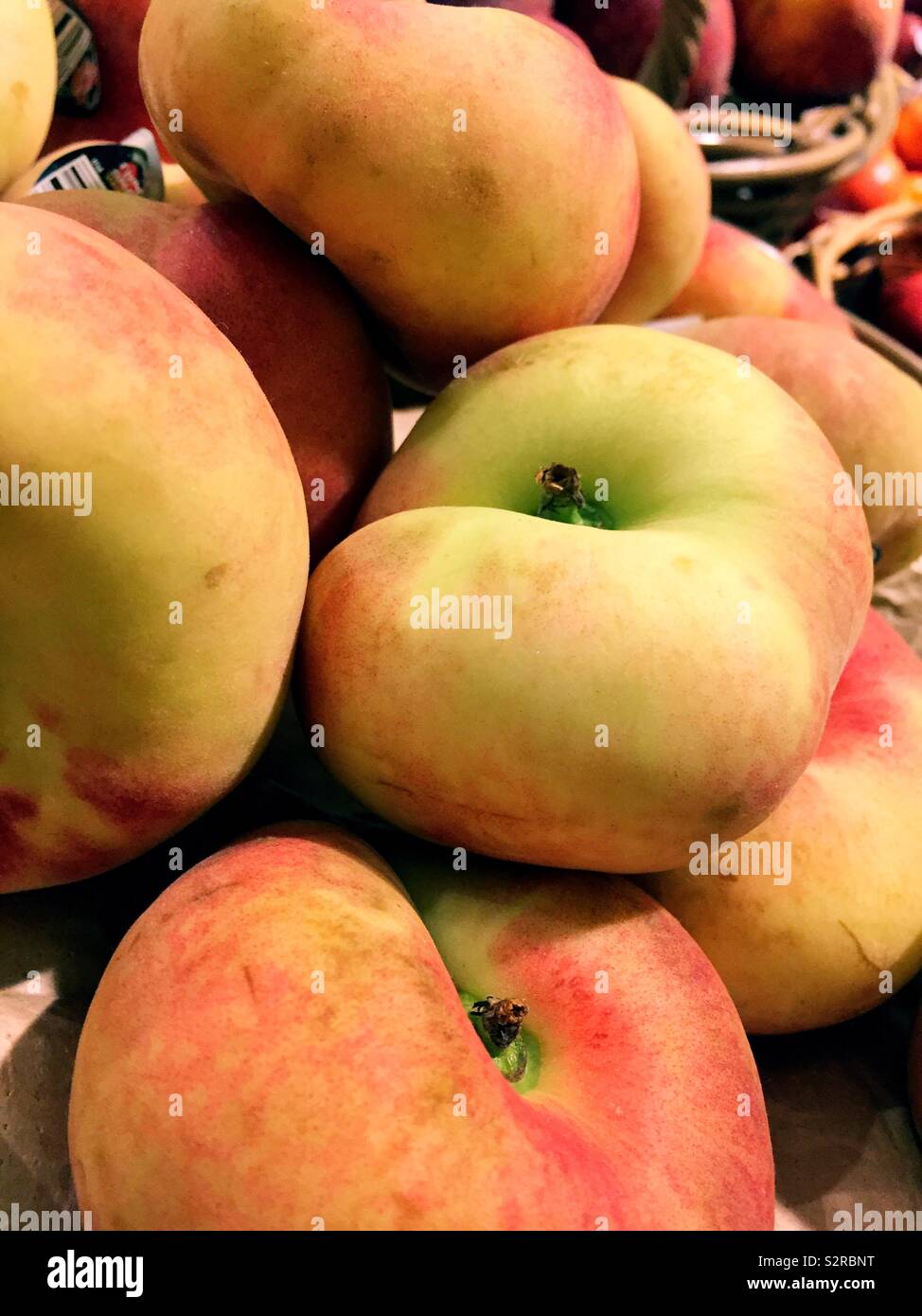Donut peaches for sale in a display at a grocery store, United States