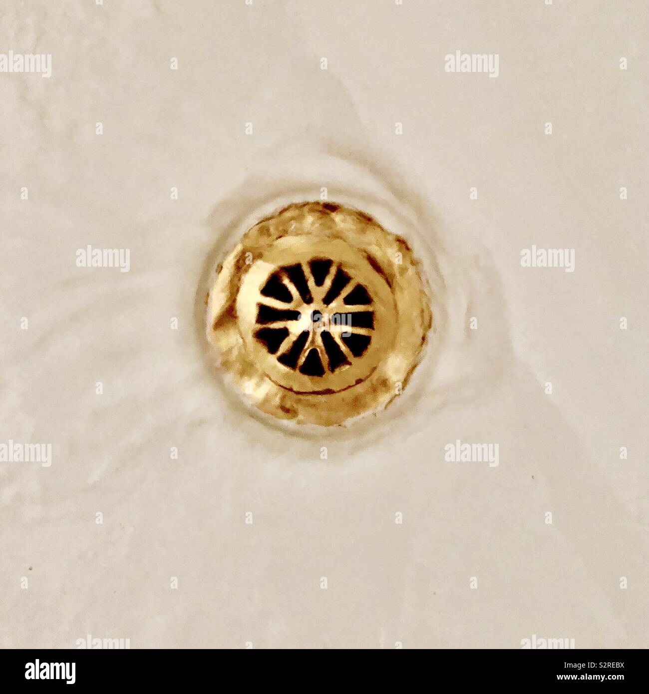 Water running down a brass drain Stock Photo