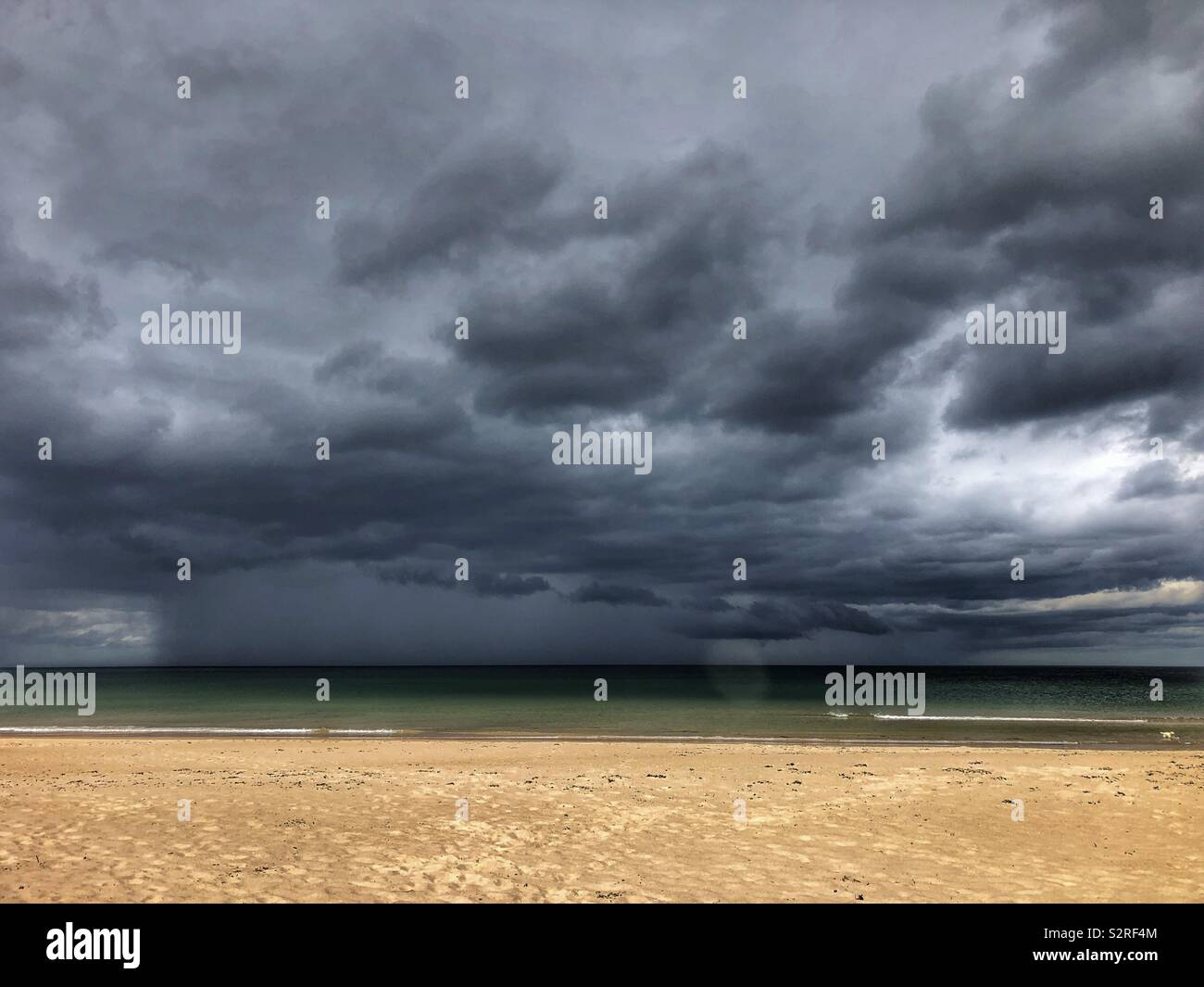 Rain showers over the sea at Ross Back Sands Northumberland - Smartphone Captured Stock Image