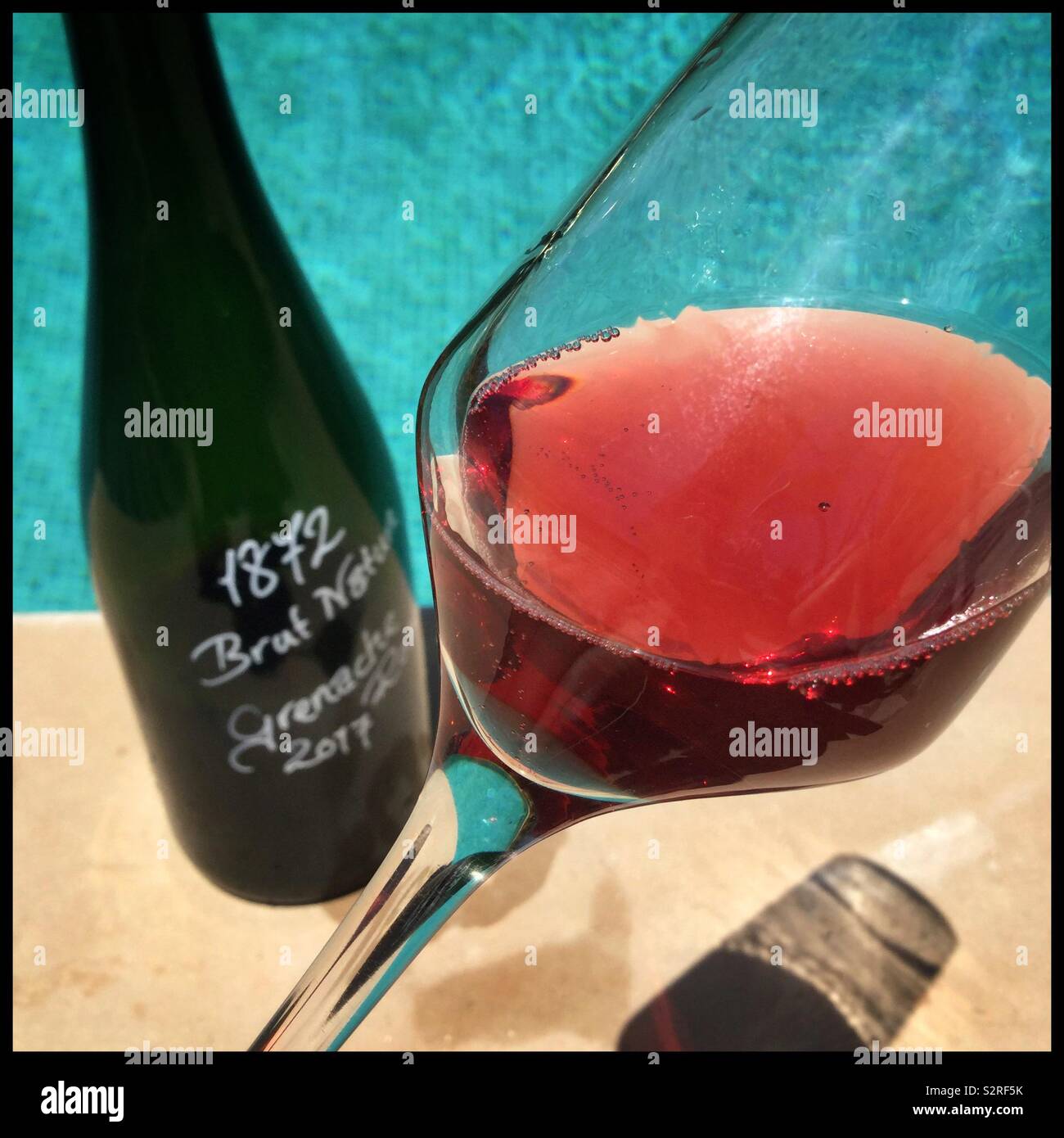 A glass of homemade sparkling Grenache rosé poolside on a summer’s day, Catalonia, Spain. - Smartphone Captured Stock Image