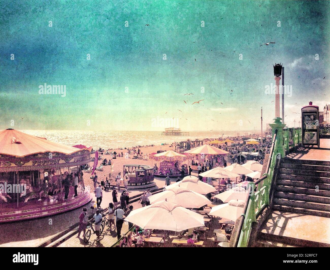 Summer day on Brighton beach showing the fairground and the ruins of the West Pier in the background - Smartphone Captured Stock Image