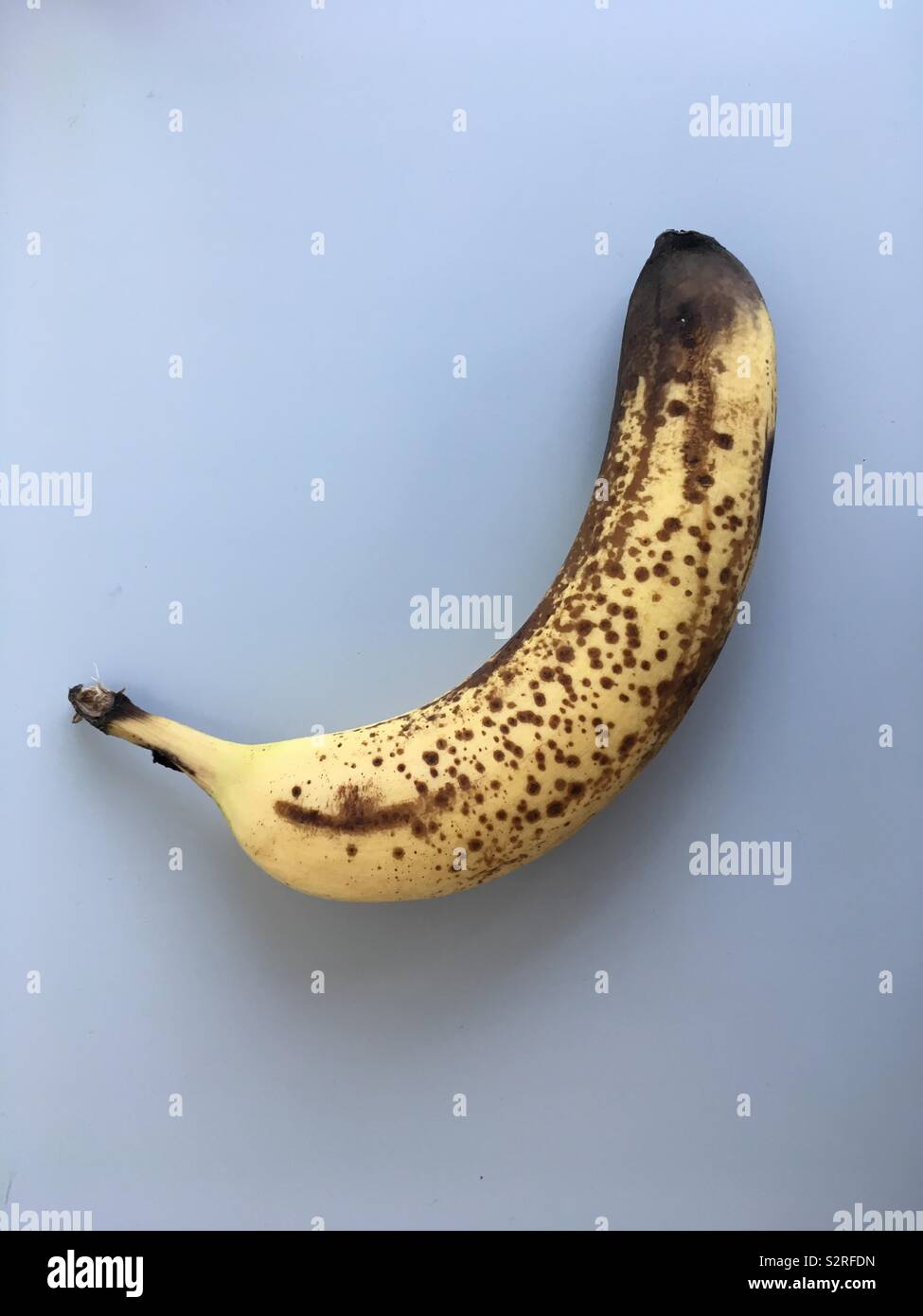 A single ripe banana on light grey background Stock Photo