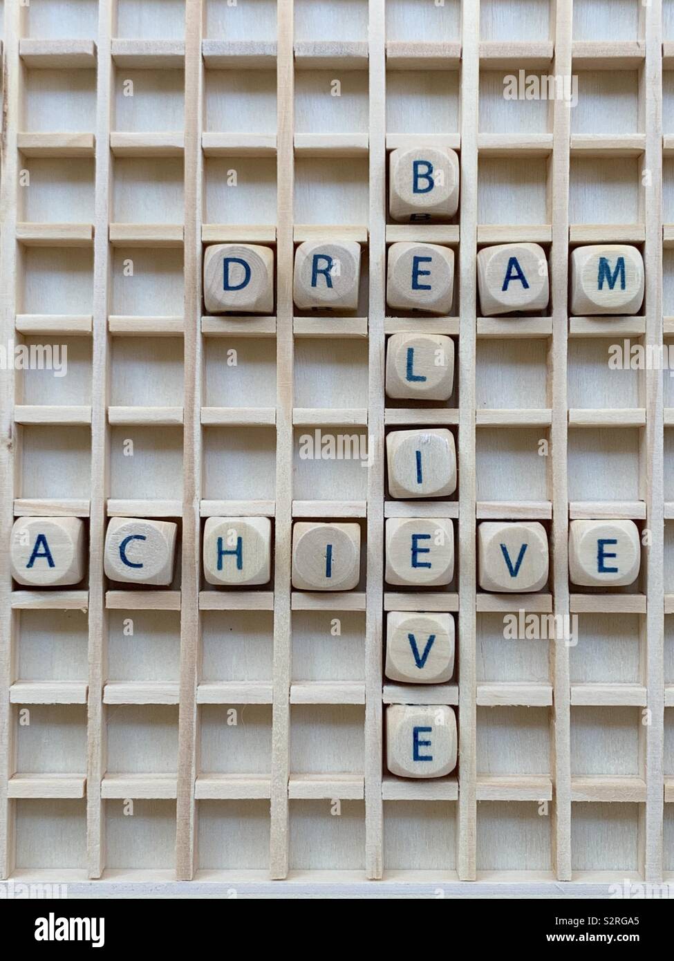 Believe, dream, achive, motivational cross words composed with wooden cube dice letters Stock Photo