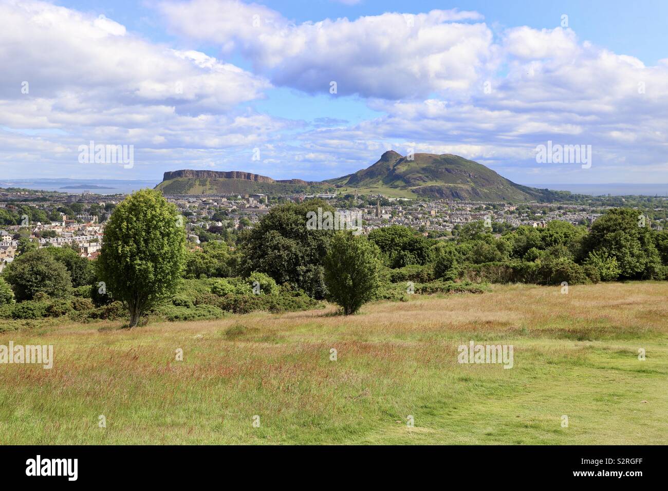 Edinburgh cityscape With Crags and Arthurs Seat as backdrop Stock Photo
