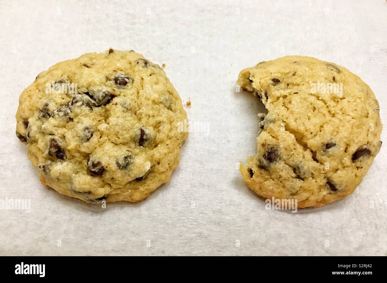Chocolate chip cookies, one whole cookie and one with a bite out of it - Smartphone Captured Stock Image