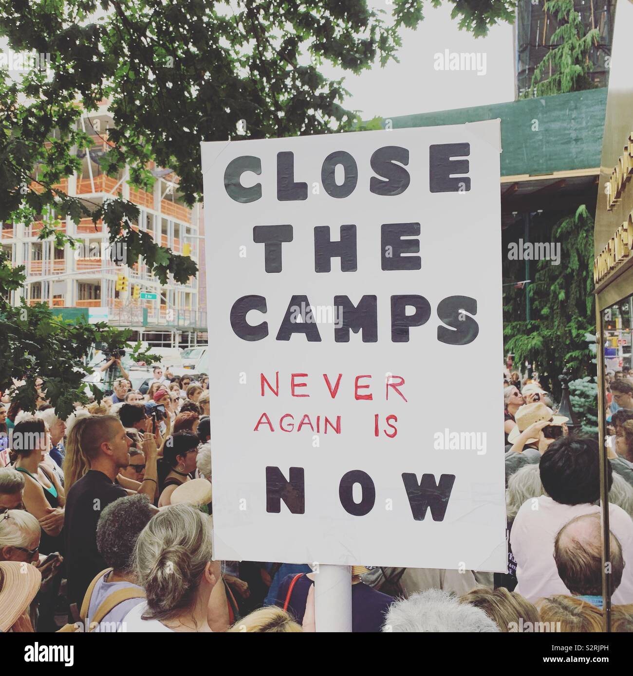 July 2, 2019. Middle Collegiate Church, Manhattan, New York City. A sign at the Close the Camps Rally reads “CLOSE THE CAMPS. NEVER AGAIN IS NOW.” - Smartphone Captured Stock Image