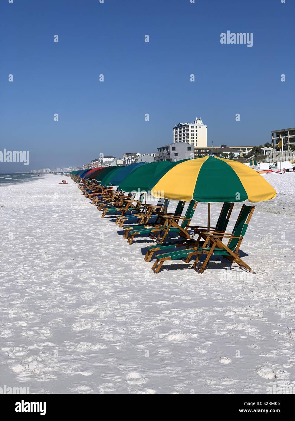 Line of colorful umbrellas on beautiful white sand on the beach - Smartphone Captured Stock Image
