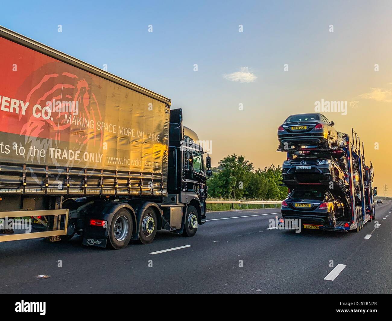 Car transporter and HGV lorries on motorway Stock Photo