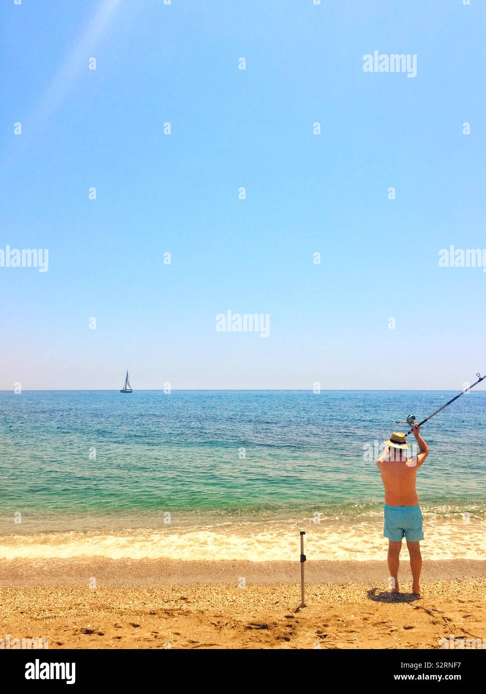 Man fishing on the beach - Smartphone Captured Stock Image