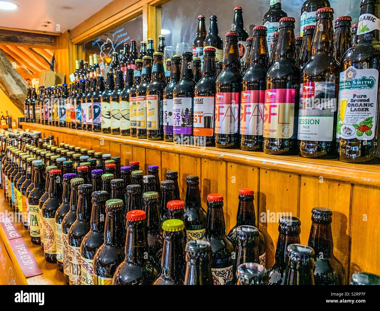 Bottles of beer and lager stacked on shelves - Smartphone Captured Stock Image
